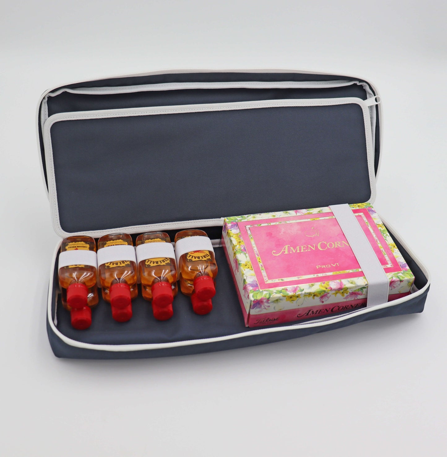 Navy Merrymaker golf organizer shown open with cinnamon whiskey nips and limited edition Masters tournament golf balls inside